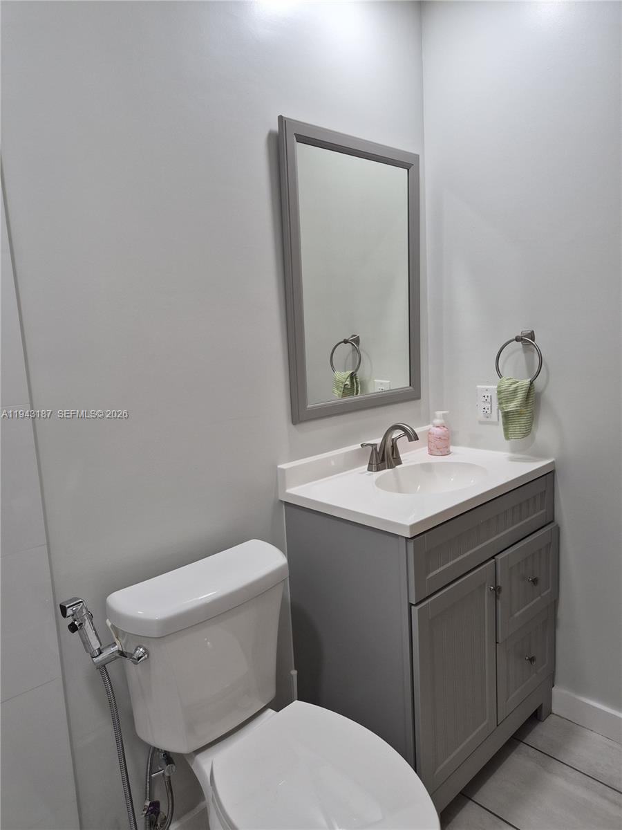 1453 Southwest 137th Place Miami, FL 33184 - Photo 19 of 22 a bathroom with a toilet sink and mirror