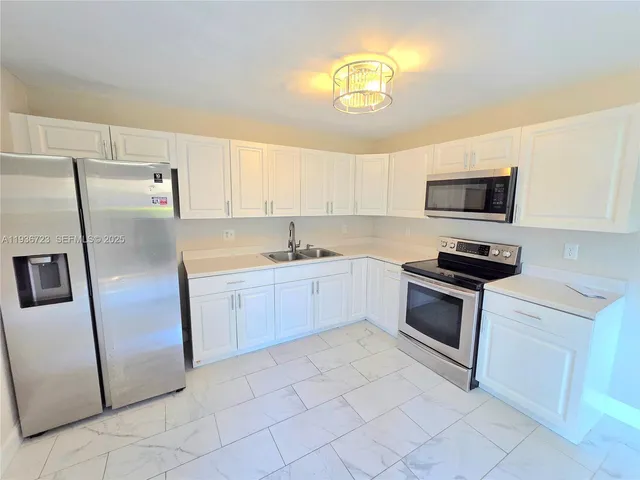 a large white kitchen with a large window