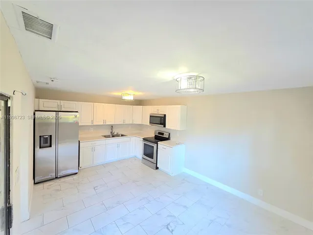 a white toilet sitting next to a bathroom sink and a mirror