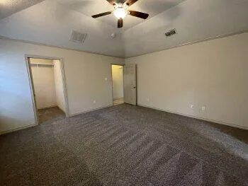 en empty room with ceiling fan and window
