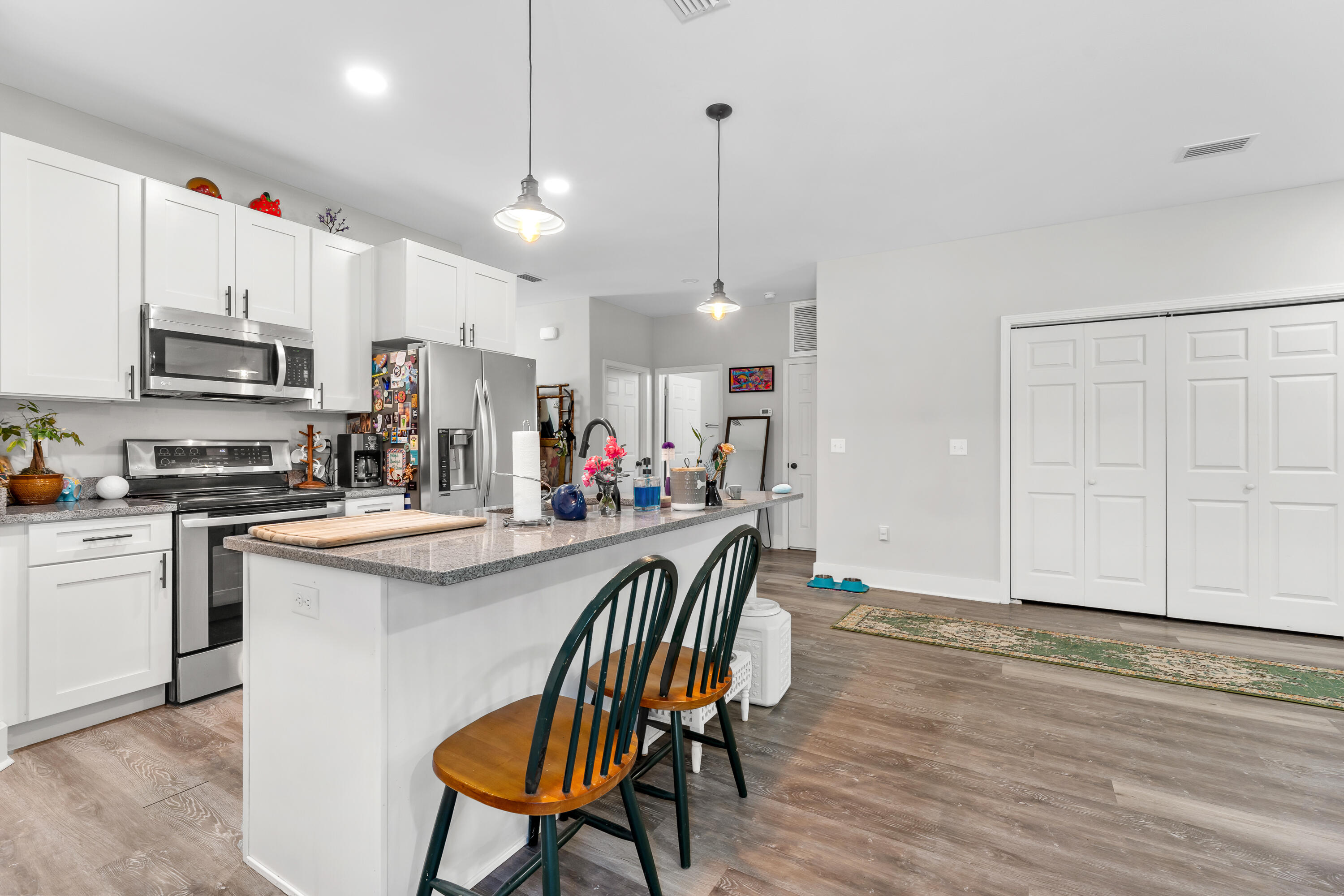 191 Indian Woman Road Santa Rosa Beach, FL 32459 - Photo 15 of 29 a kitchen with stainless steel appliances granite countertop a stove top oven a refrigerator a sink and a dining table with wooden floor