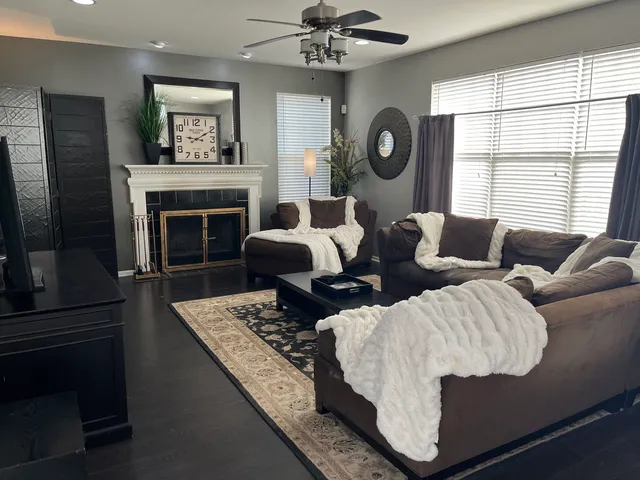 a living room with furniture a flat screen tv and a fireplace