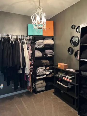 a view of walk in closet with clothes and shoes