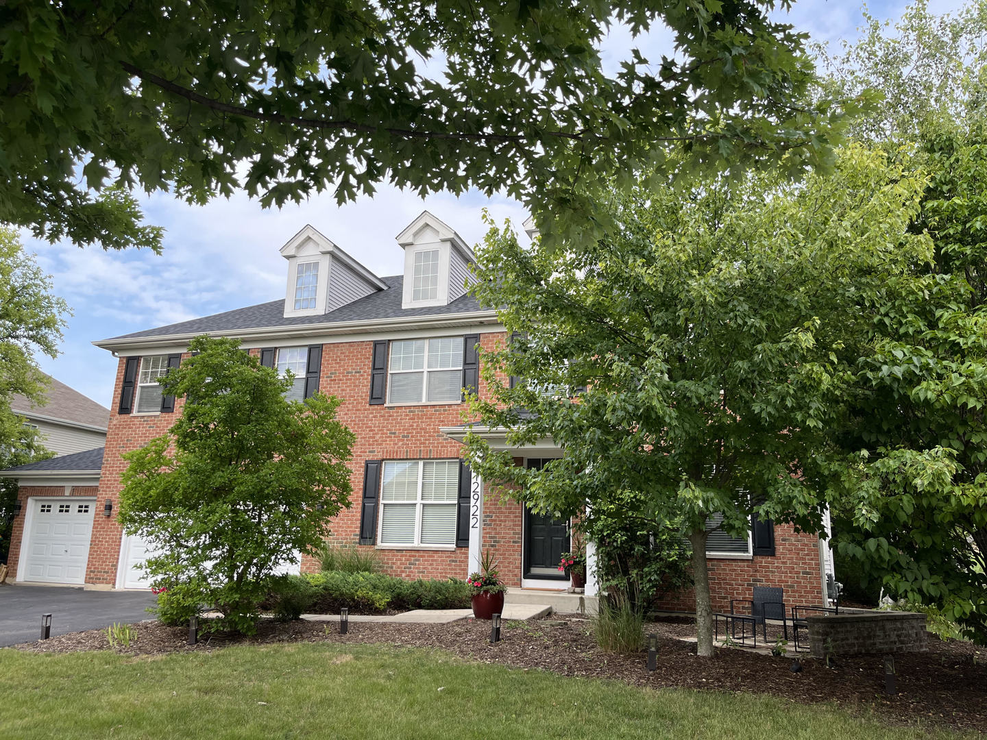 12922 Grande Poplar Circle Plainfield, IL 60585 - Photo 2 of 47 a front view of a house with a garden