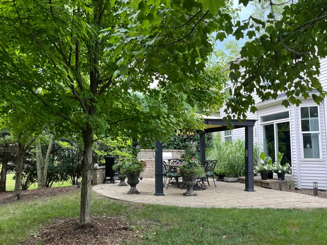 a view of a patio with table and chairs under an umbrella