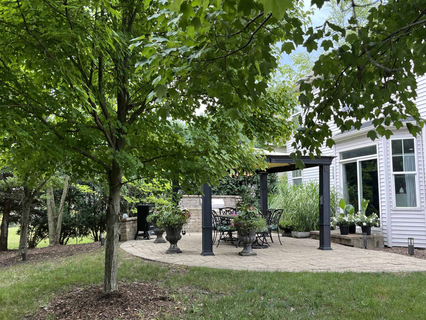 12922 Grande Poplar Circle Plainfield, IL 60585 - Photo 5 of 47 a view of a patio with table and chairs under an umbrella