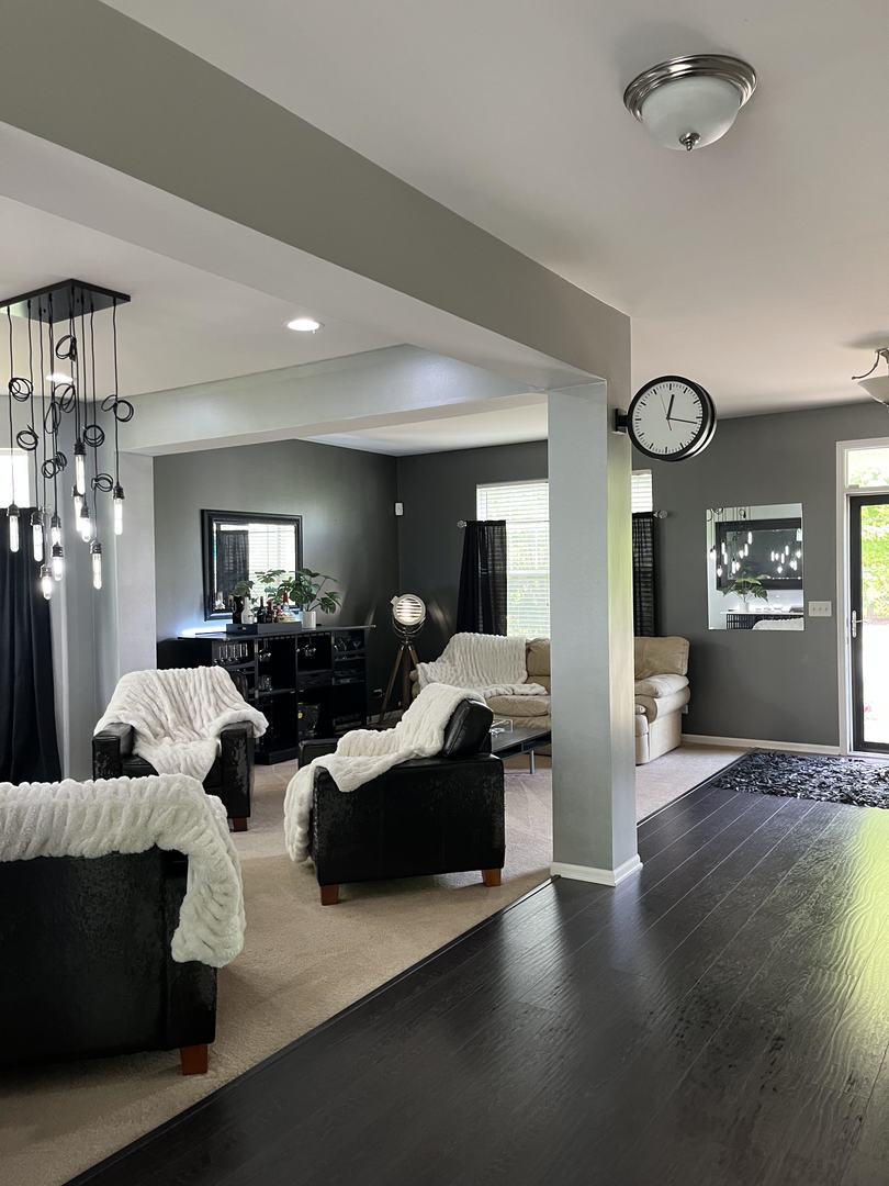 12922 Grande Poplar Circle Plainfield, IL 60585 - Photo 7 of 47 a living room with couches and a large mirror with wooden floor
