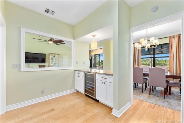 a view of a hallway with dining room and wooden floor