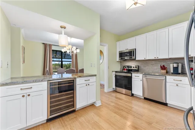 a kitchen with granite countertop a sink cabinets and stainless steel appliances