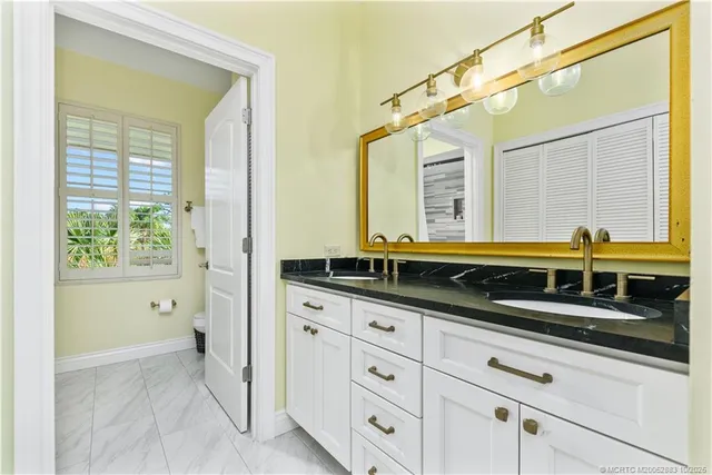 a bathroom with a granite countertop sink mirror and double