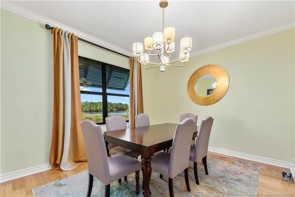 a view of a dining room with furniture a chandelier and wooden floor