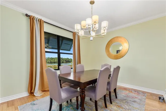 a view of a dining room with furniture a chandelier and wooden floor