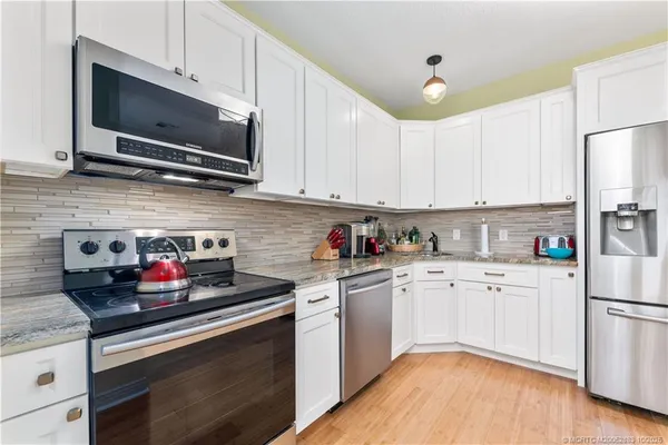 a kitchen with stainless steel appliances granite countertop a stove a sink dishwasher and a refrigerator