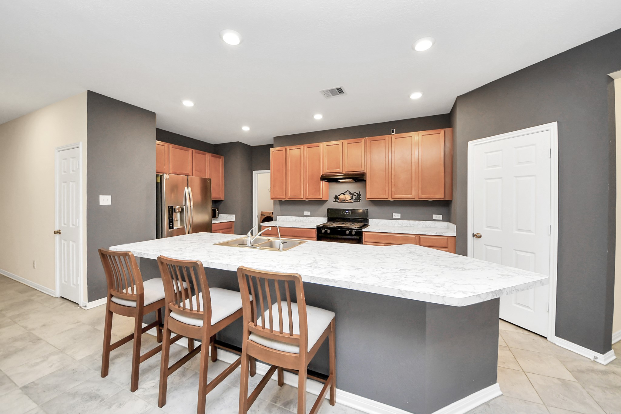 a kitchen with granite countertop a table chairs stove a sink and dishwasher