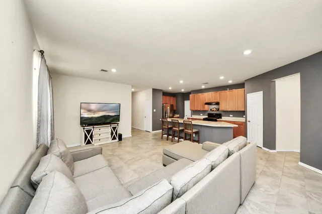 a view of a living room kitchen and a large window