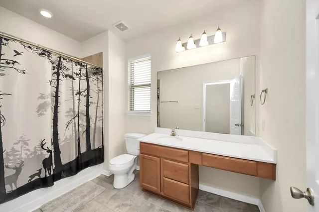 a bathroom with a double vanity sink toilet mirror and shower