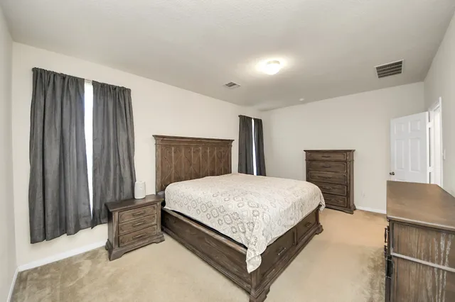 a bedroom with a bed and a dresser with mirror
