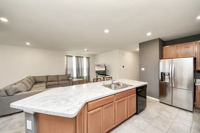 a kitchen with stainless steel appliances granite countertop a sink refrigerator and cabinets