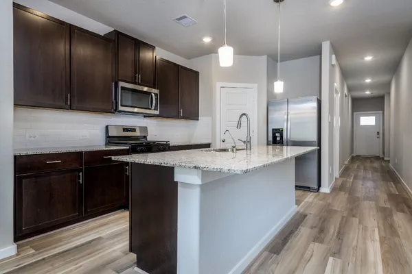 a kitchen with stainless steel appliances granite countertop a sink stove and microwave