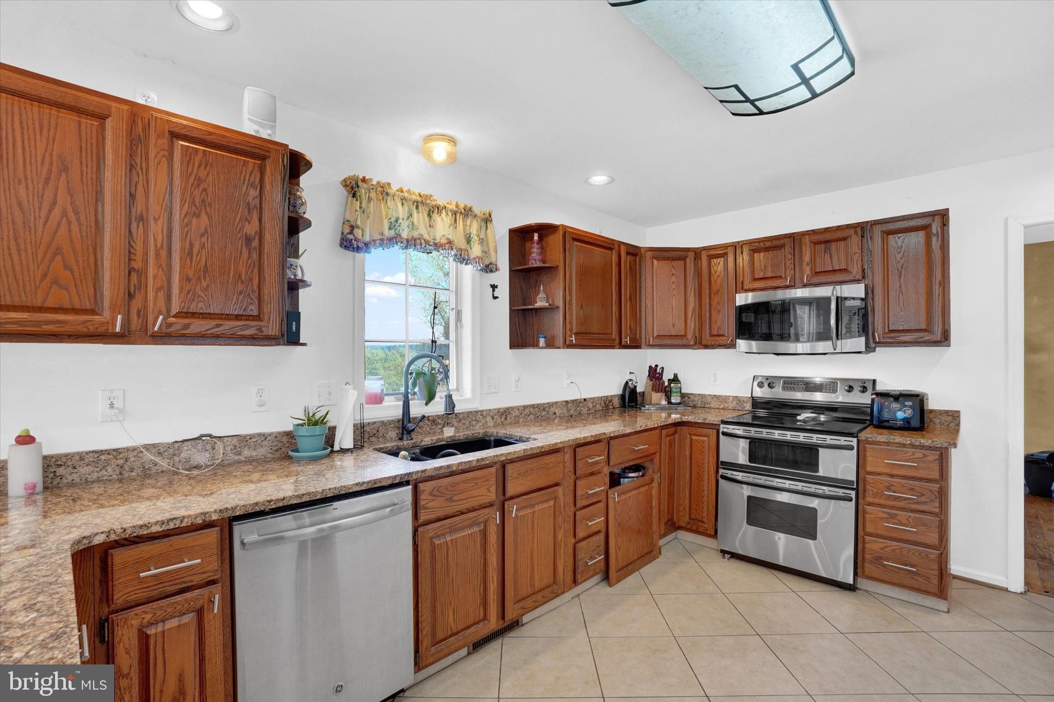 243 Bald Eagle Road Fawn Grove, PA 17321 - Photo 7 of 44 a kitchen with stainless steel appliances granite countertop a sink and stove top oven
