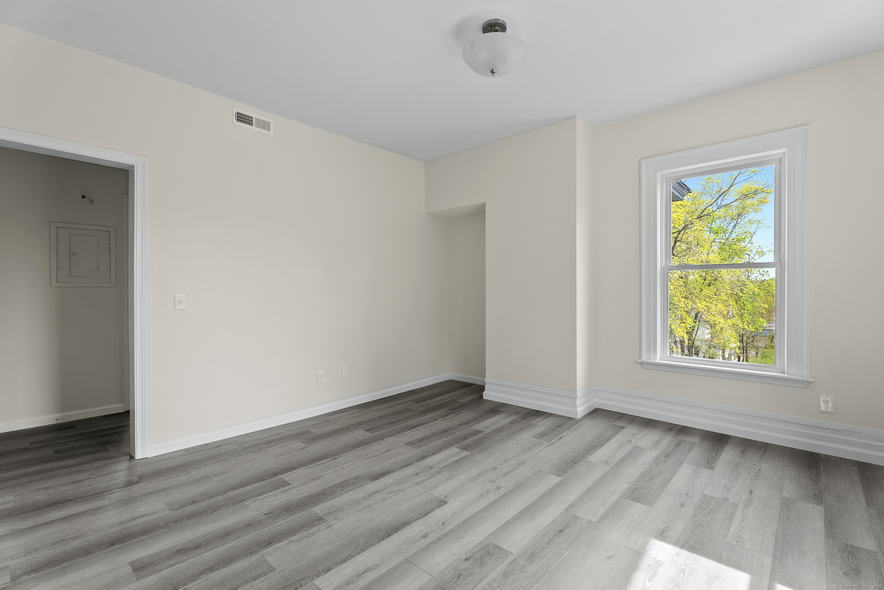 72 South Main Street, Unit 2C Wallingford, CT 06492 - Photo 2 of 10 an empty room with wooden floor and window