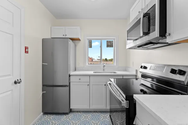 a kitchen with stainless steel appliances a refrigerator stove and sink