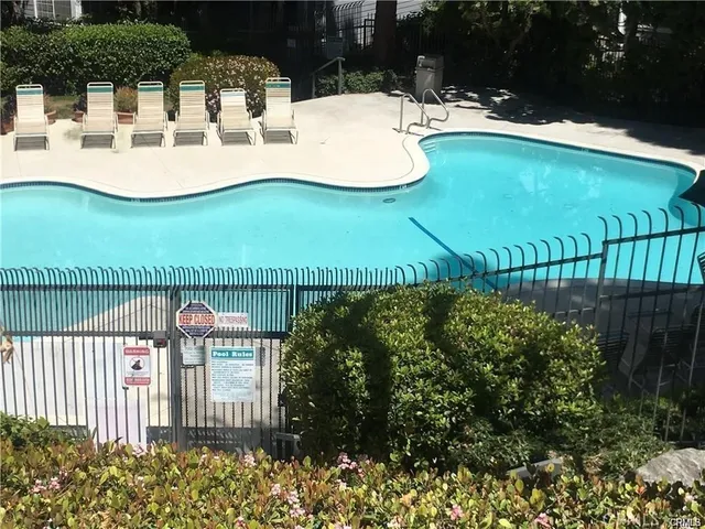 a view of a white house with swimming pool and patio