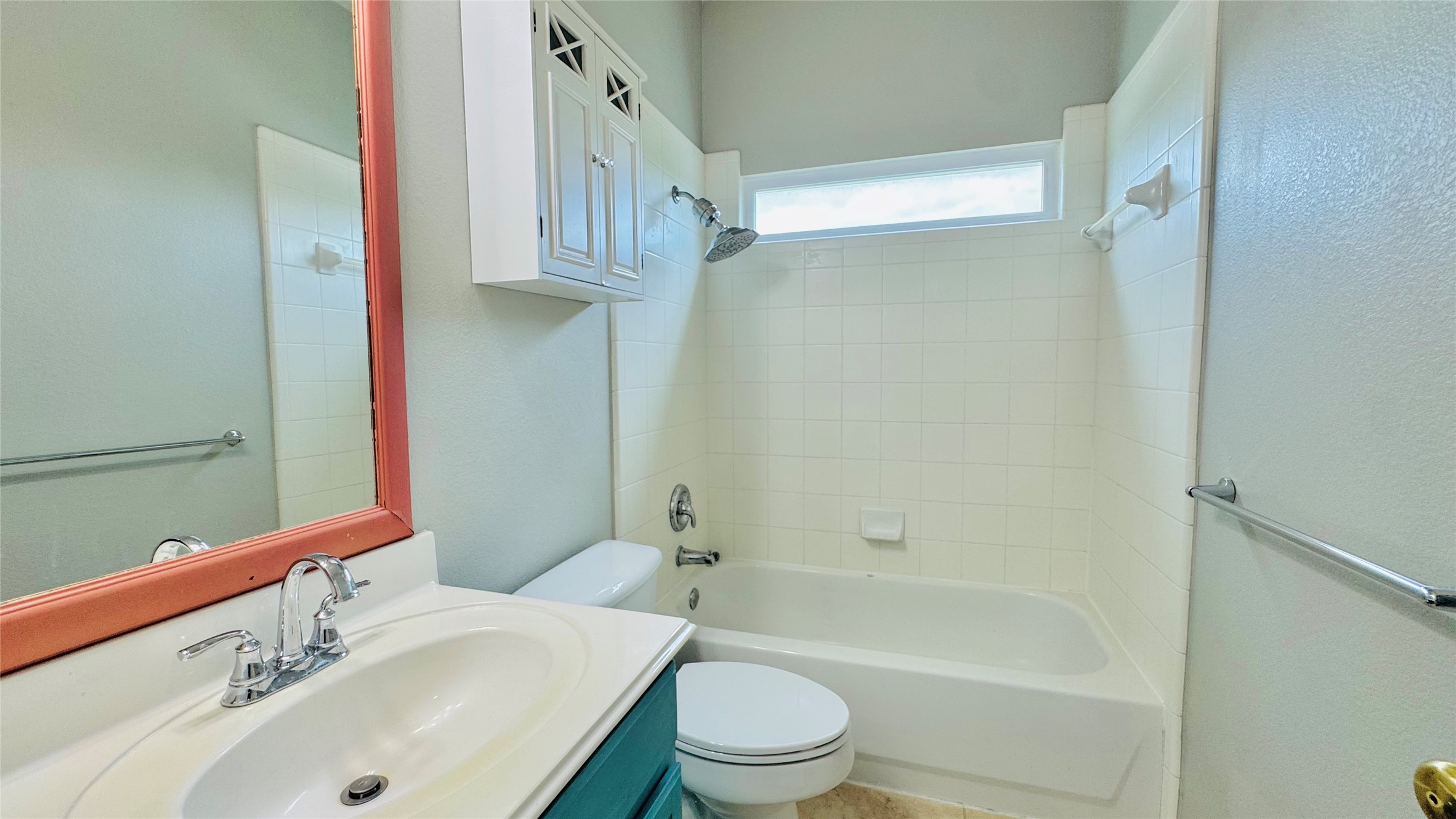 401 Witte Road Kyle, TX 78640 - Photo 20 of 24 Upper level-Tiled bath and shower with a window above, complemented by a vanity with sink and mirror.