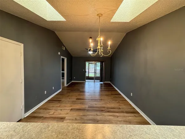 a empty room with ceiling fan and window