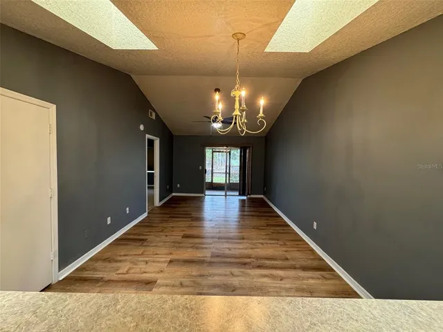 a empty room with ceiling fan and window