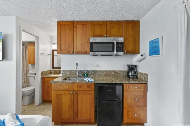 a kitchen with a sink a microwave a stove and cabinets