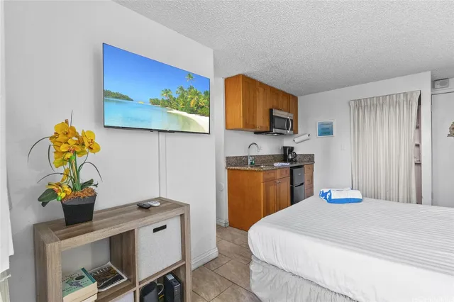 a bedroom with a bed and a computer on a table