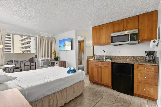 a large kitchen with stainless steel appliances granite countertop a stove a sink dishwasher and a microwave oven with white cabinets