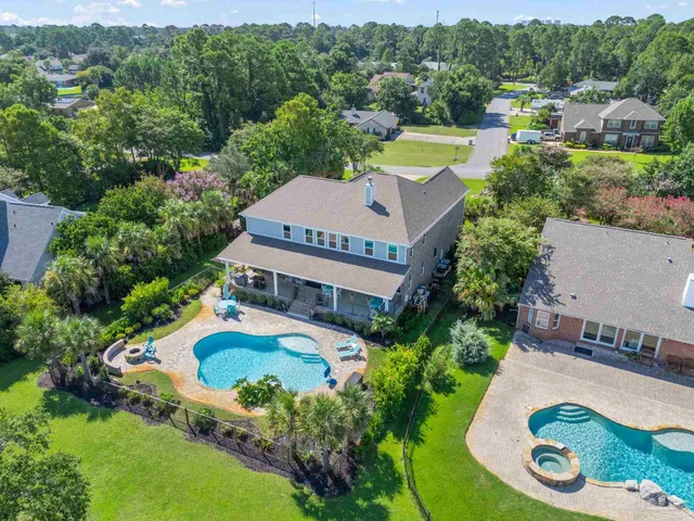an aerial view of a house with a garden and lake view