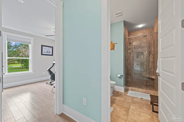 a view of a hallway with wooden floor and windows