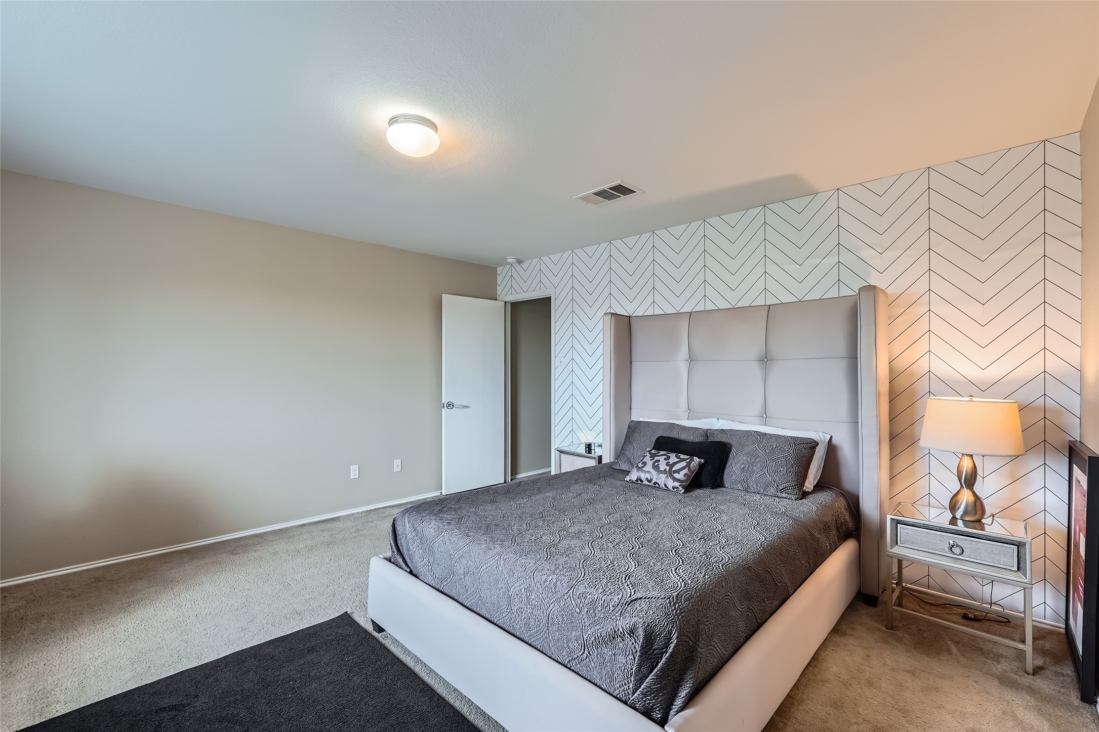 18021 Prairie Verbena Lane Elgin, TX 78621 - Photo 20 of 33 A plush bed with a tufted headboard is perfectly centered against a decorative accent wall.