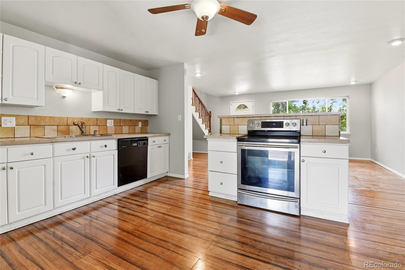 7461 Webster Street Arvada, CO 80003 - Photo 8 of 31 a kitchen with stainless steel appliances granite countertop a stove top oven and cabinets