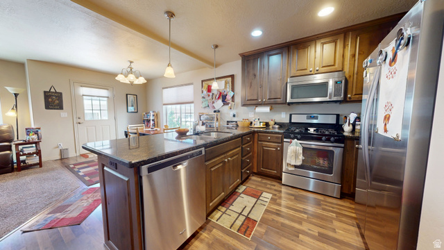 1674 Eastridge Road Price, UT 84501 - Photo 6 of 34 Kitchen featuring wood-finish flooring, dark stone countertops, wood cabinetry, and a full suite of stainless steel appliances