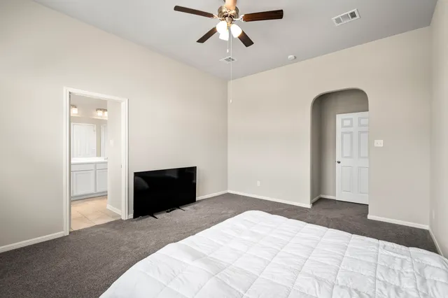 a bedroom with a bed and a ceiling fan