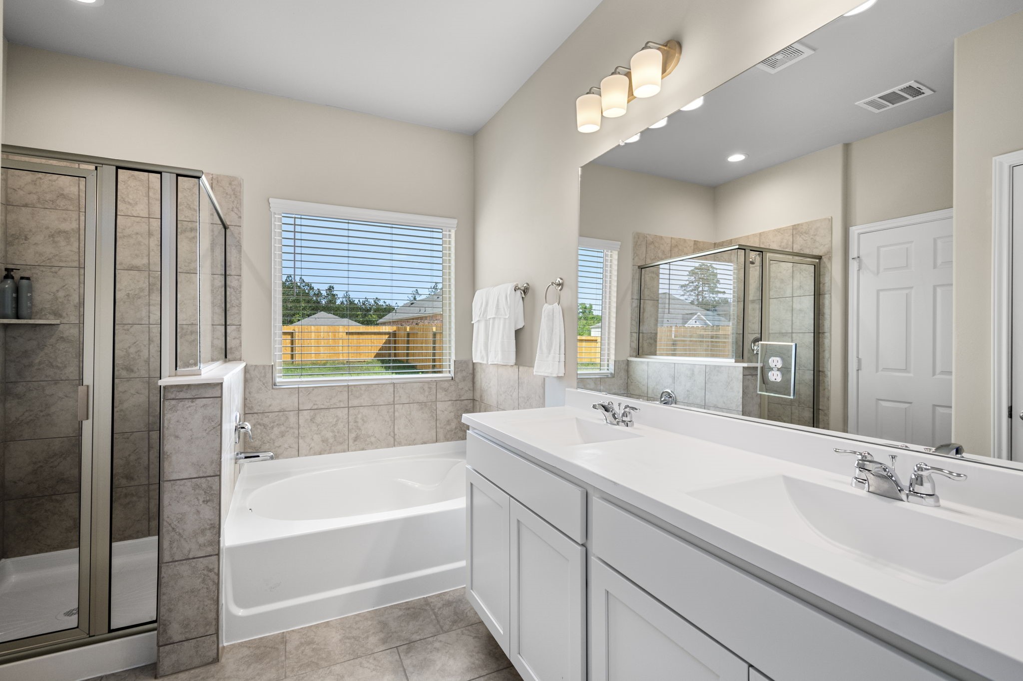 26019 Babe Ruth Drive Splendora, TX 77372 - Photo 19 of 23 a bathroom with a tub sink shower and a mirror