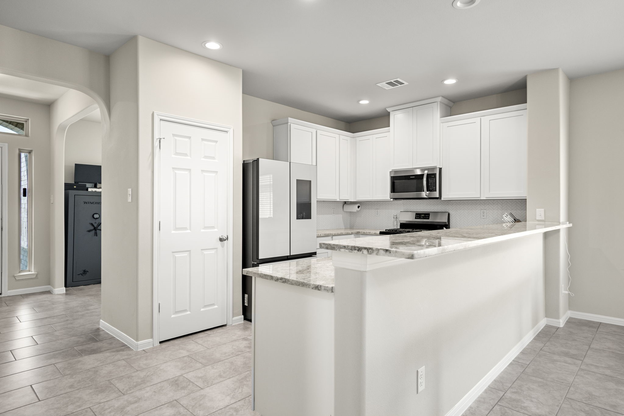 26019 Babe Ruth Drive Splendora, TX 77372 - Photo 7 of 23 a kitchen with stainless steel appliances a refrigerator stove microwave and white cabinets