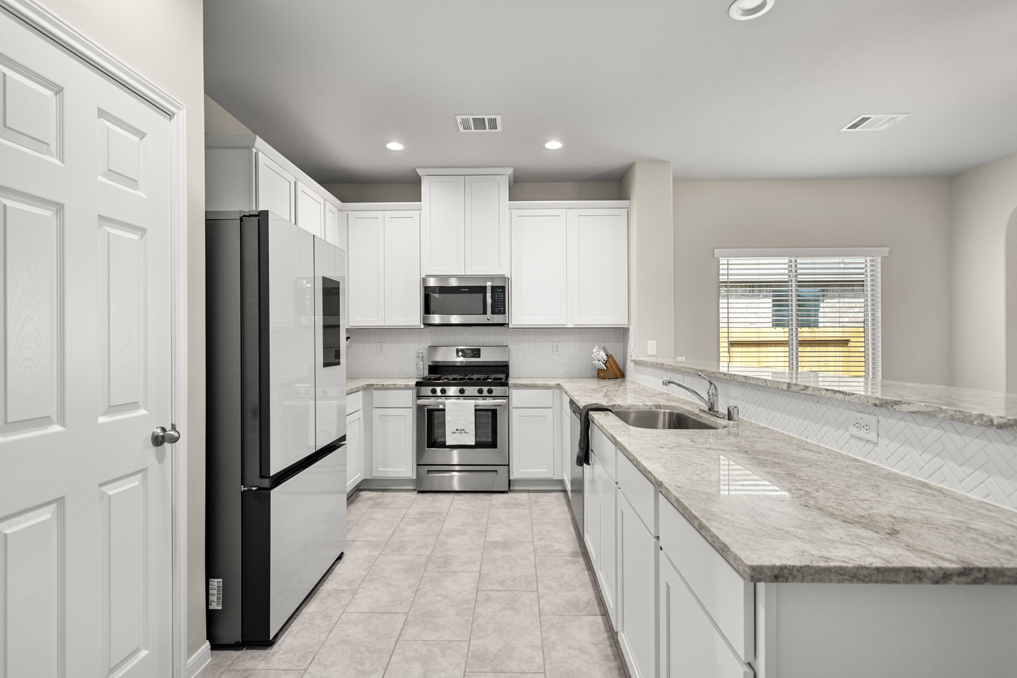 26019 Babe Ruth Drive Splendora, TX 77372 - Photo 8 of 23 a kitchen with stainless steel appliances granite countertop a sink stove and refrigerator