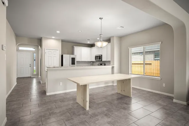 a kitchen with kitchen island a stove a refrigerator and a sink