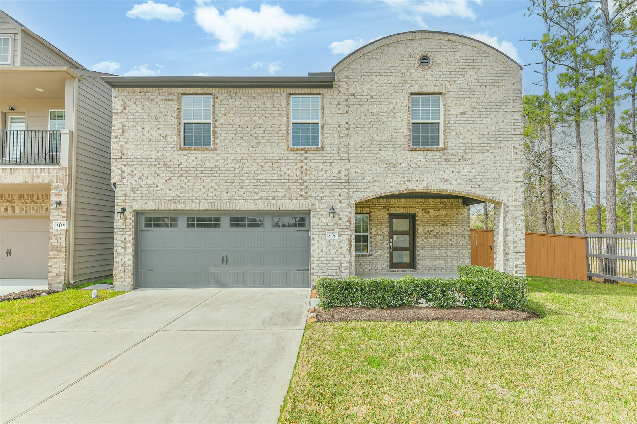 2129 Solstice Boulevard Spring, TX 77386 - Photo 2 of 43 Beautiful brick exterior with a welcoming covered front porch and modern front door. Well-kept landscaping and an extended driveway leading to a spacious two-car garage. Large lot with side fencing and mature trees for added privacy.