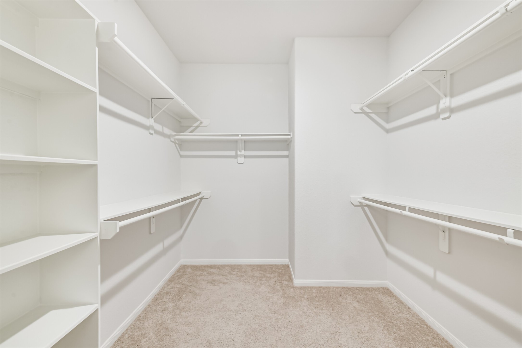 2129 Solstice Boulevard Spring, TX 77386 - Photo 30 of 43 Primary Walk-In Closet:
Spacious walk-in closet with built-in shelving and ample hanging space on all sides. Neutral finishes and great storage capacity for an organized wardrobe.