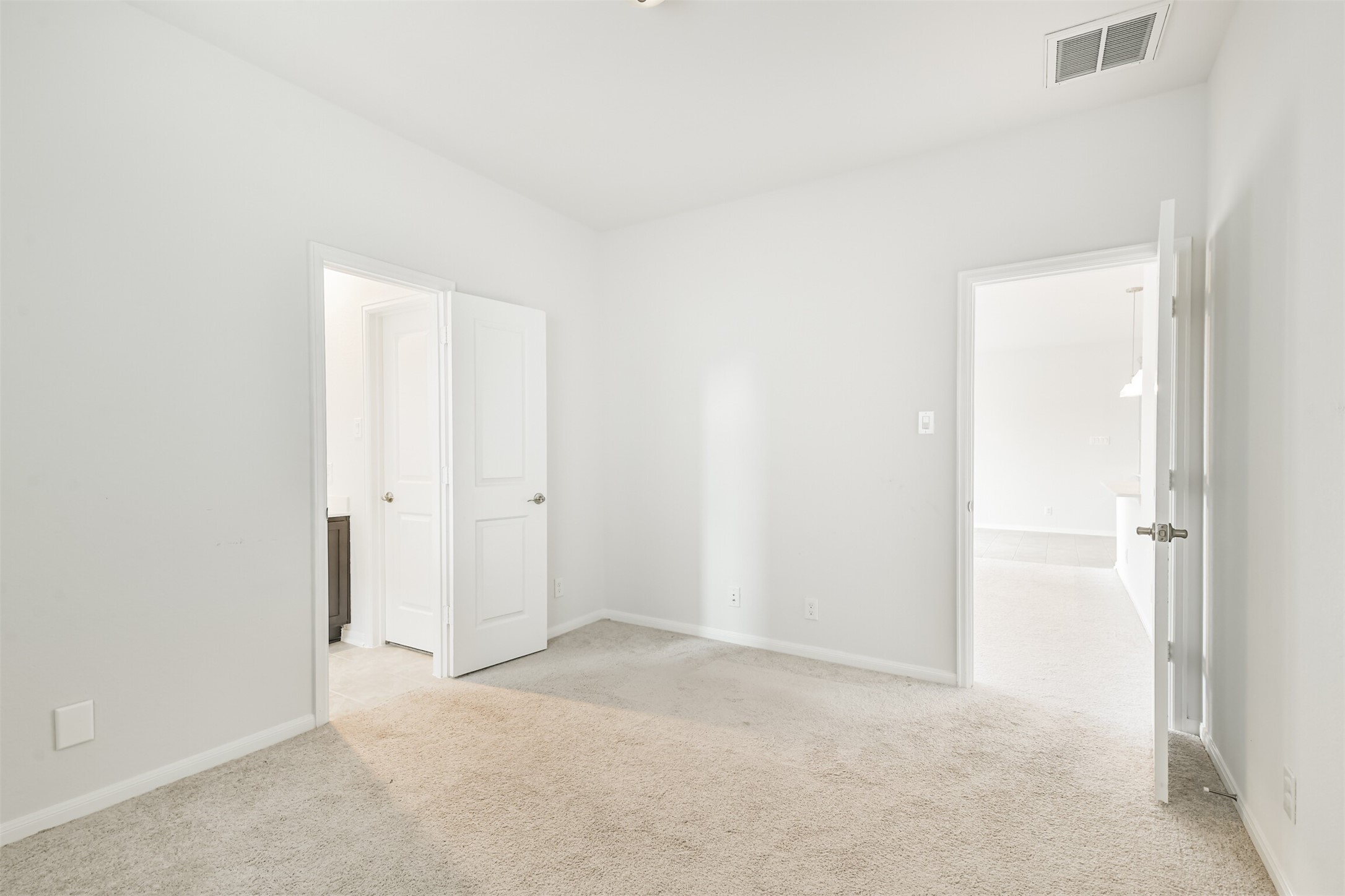 2129 Solstice Boulevard Spring, TX 77386 - Photo 32 of 43 Bedroom:
Bright secondary bedroom with neutral carpet and paint, offering easy access to both the adjoining bathroom and main living areas. A great space for guests, kids, or a home office.