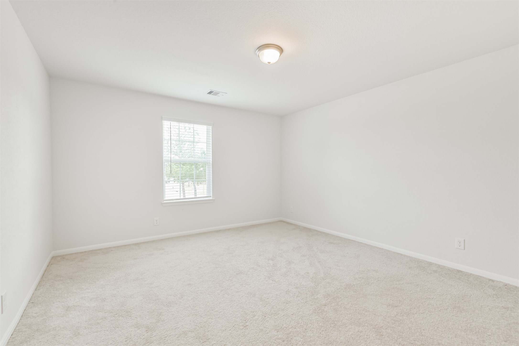 2129 Solstice Boulevard Spring, TX 77386 - Photo 39 of 43 Spacious secondary bedroom with soft natural light, neutral paint, and plush carpet—an easy space to personalize as a guest room, office, or playroom.