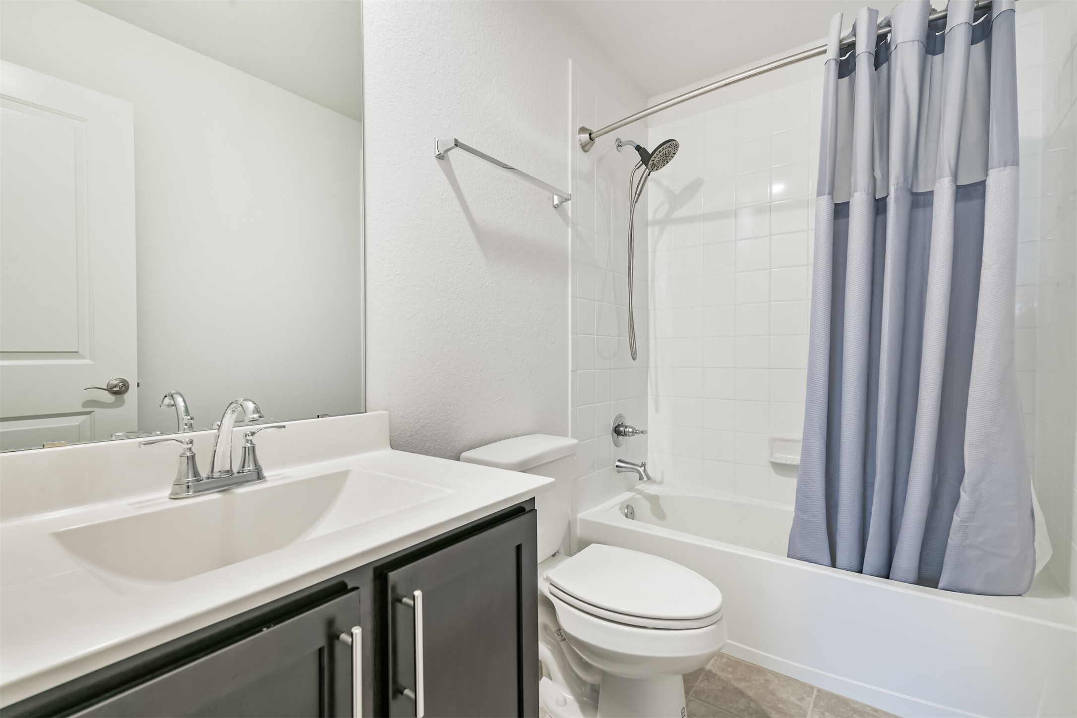 2129 Solstice Boulevard Spring, TX 77386 - Photo 41 of 43 Bright full bath with a large vanity, fresh white tile tub/shower combo, and neutral finishes throughout. Conveniently located for guests or secondary bedrooms.