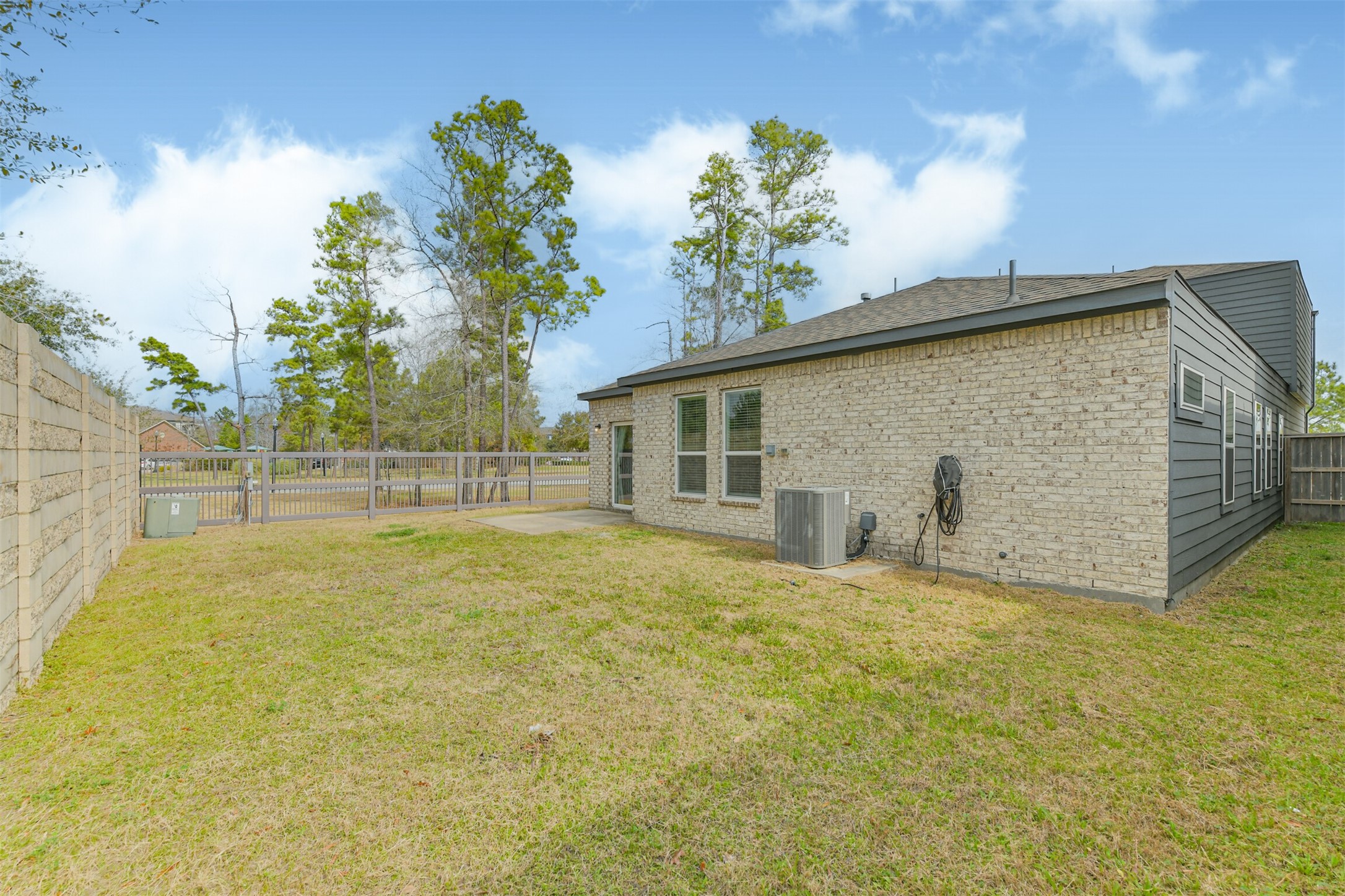 2129 Solstice Boulevard Spring, TX 77386 - Photo 8 of 43 Spacious backyard with a concrete patio and plenty of room for play or outdoor seating. No direct back neighbors, offering added privacy and a peaceful view of the surrounding green space.