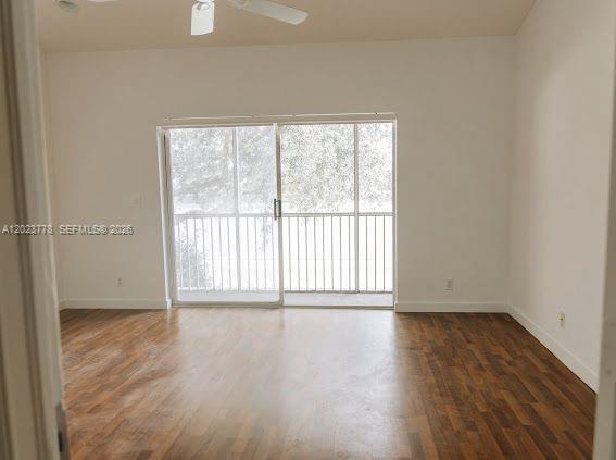 10245 Vía Hibiscus, Unit 10245 Boca Raton, FL 33428 - Photo 10 of 28 an empty room with wooden floor and windows